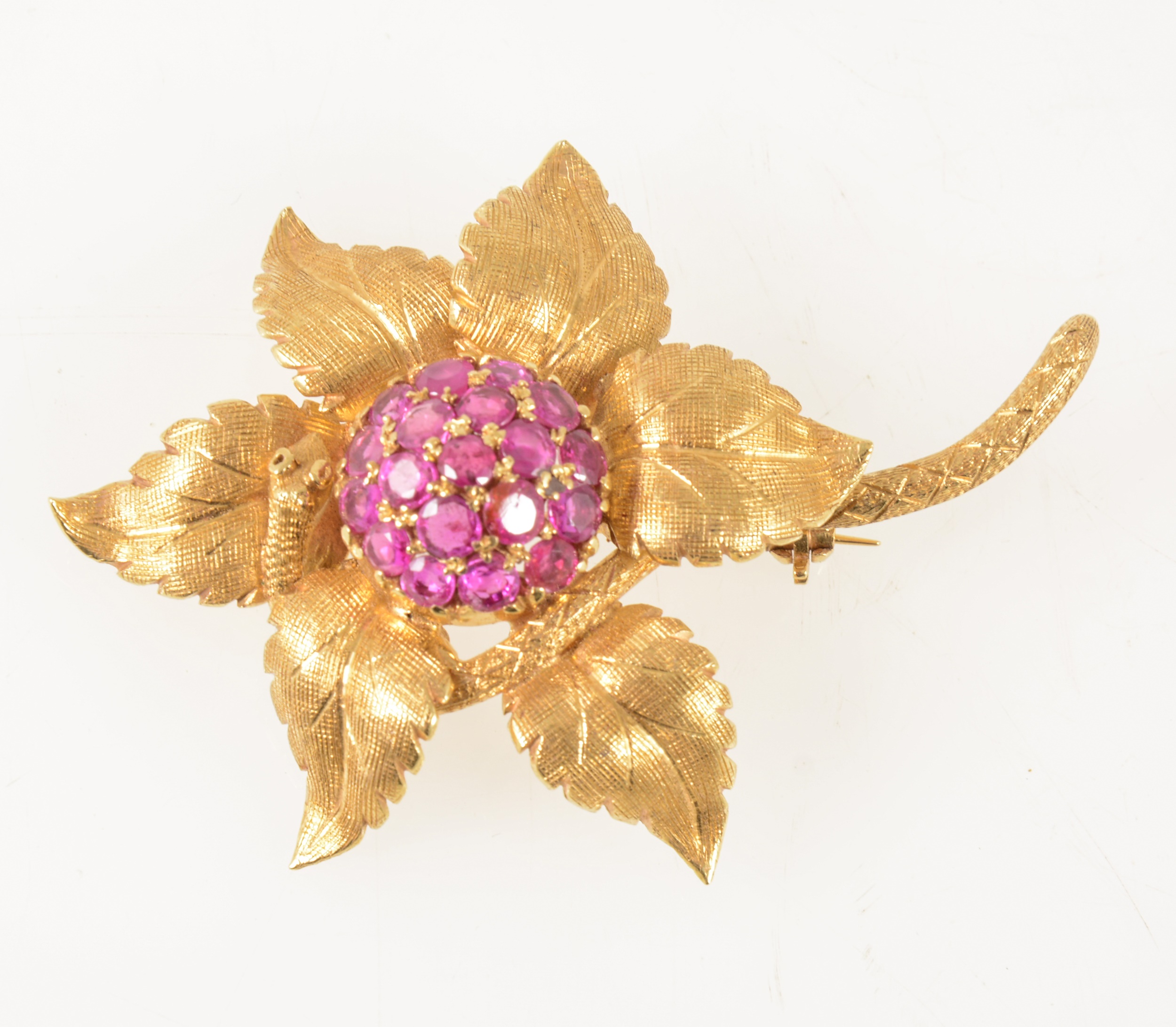 An 18 carat yellow gold and ruby floral brooch.