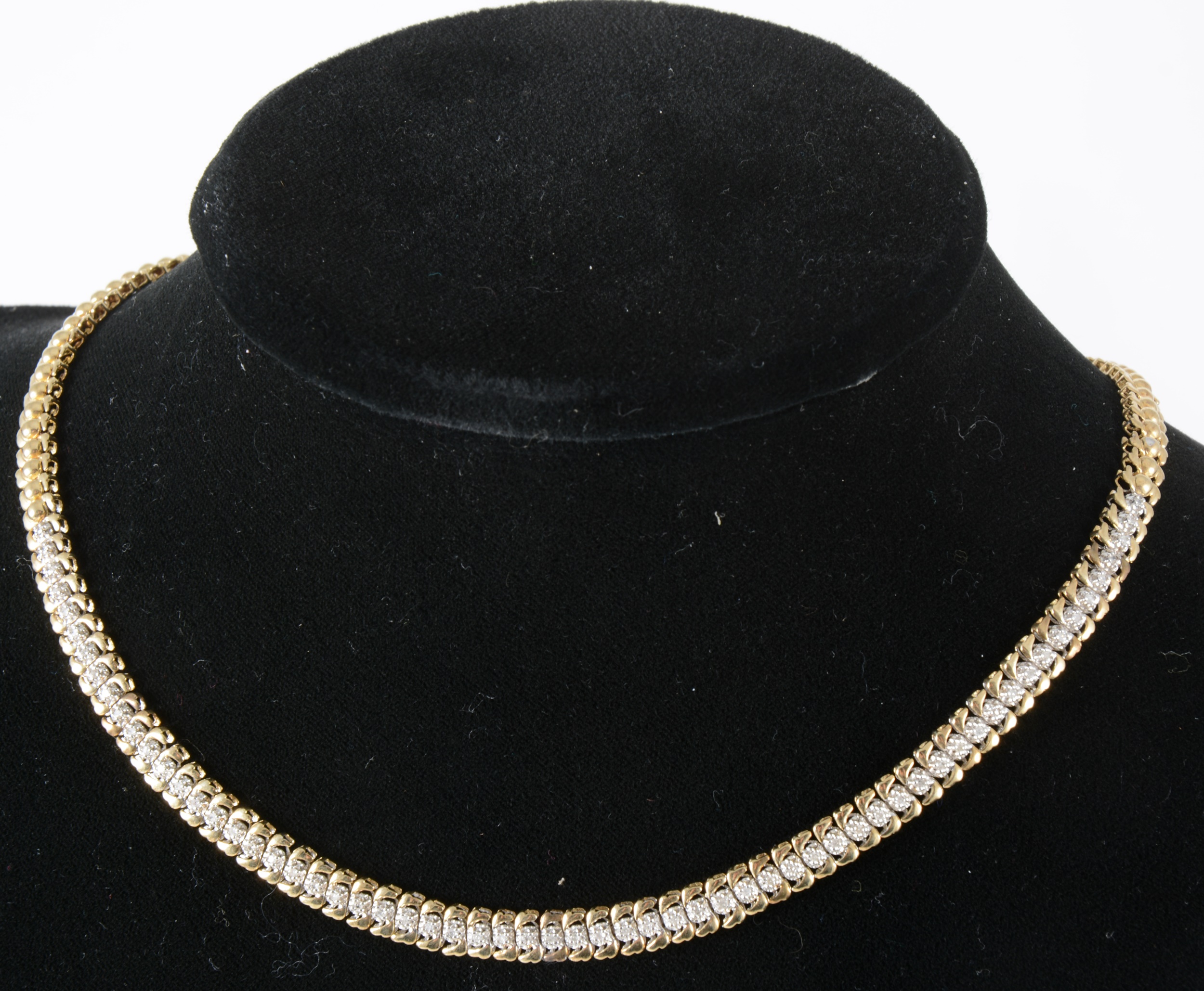 A 9 carat yellow and white gold collar necklace set with small diamonds.