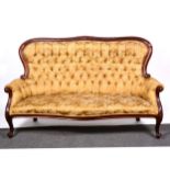 A Victorian mahogany sofa, upholstered in buttoned Old Gold brocade