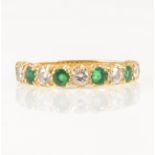 An emerald and diamond half eternity ring.