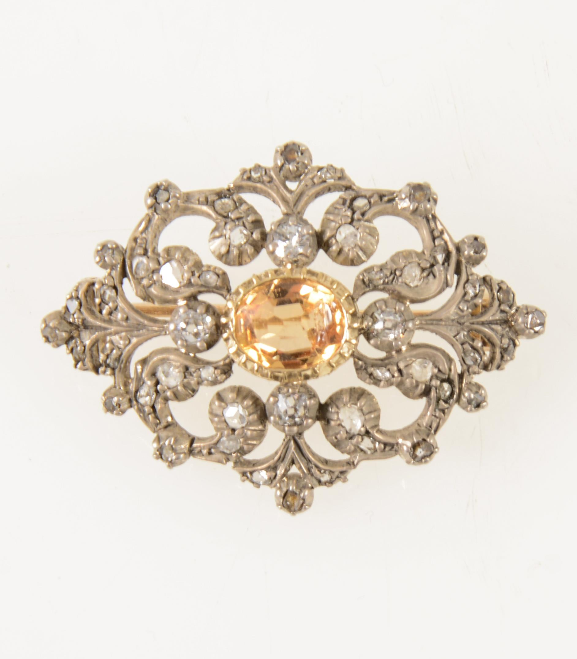 A late Victorian diamond brooch with golden yellow stone to centre,