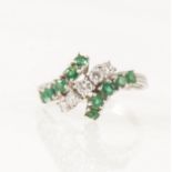 An emerald and diamond crossover ring.