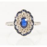 A sapphire and diamond oval cluster ring in the Art Deco style.