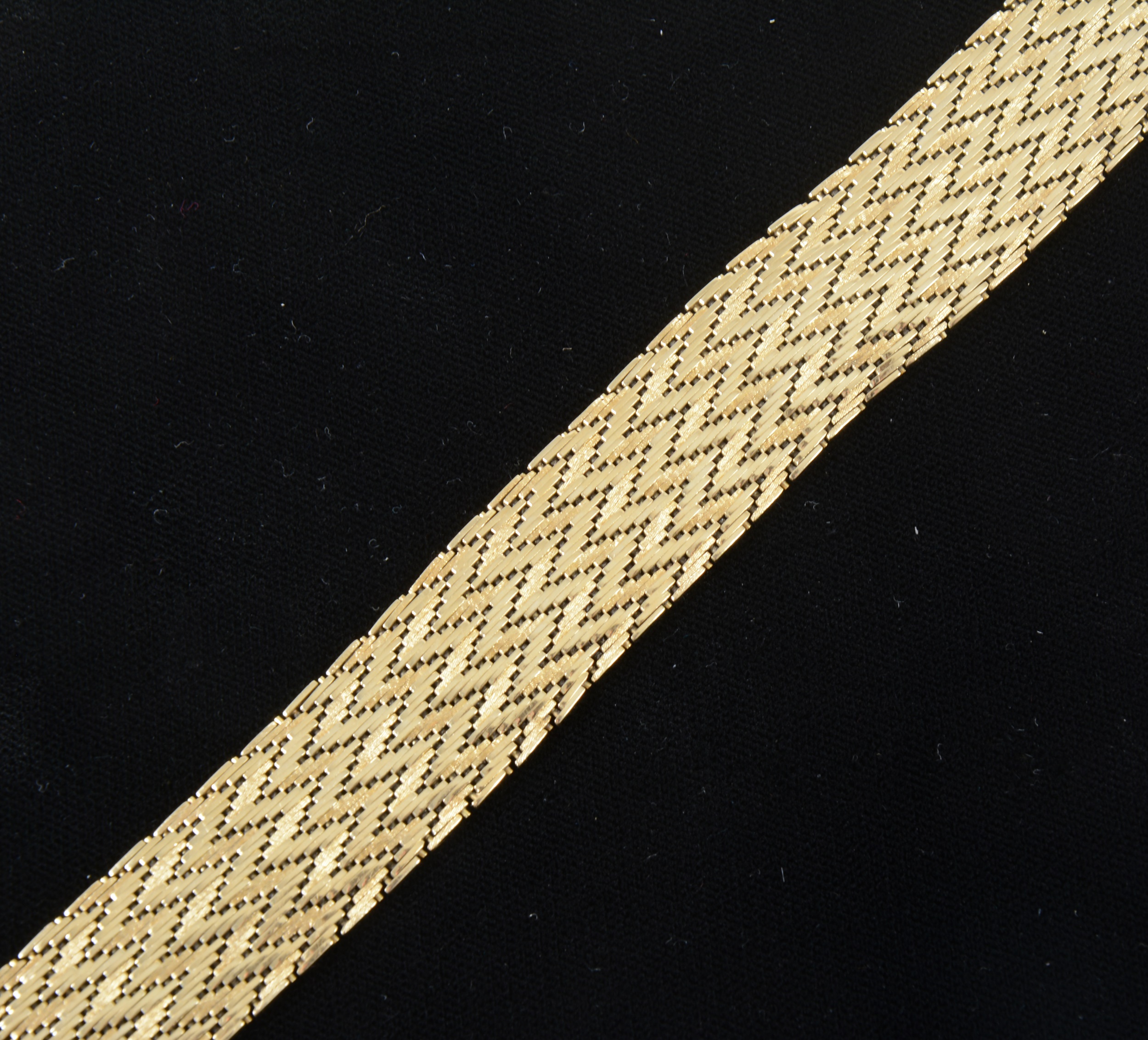 An 18 carat yellow gold 20mm wide flexible herringbone design bracelet.