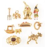 Eight various gold and yellow metal charms and a necklace fastener