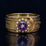 A late 19th Century yellow metal bangle with an amethyst, diamond and pearl cluster.