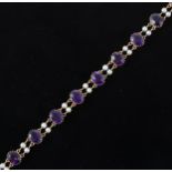 An amethyst and pearl bracelet, strung with ten oval cut stones, 10mm x 8mm with pairs of 3.8mm