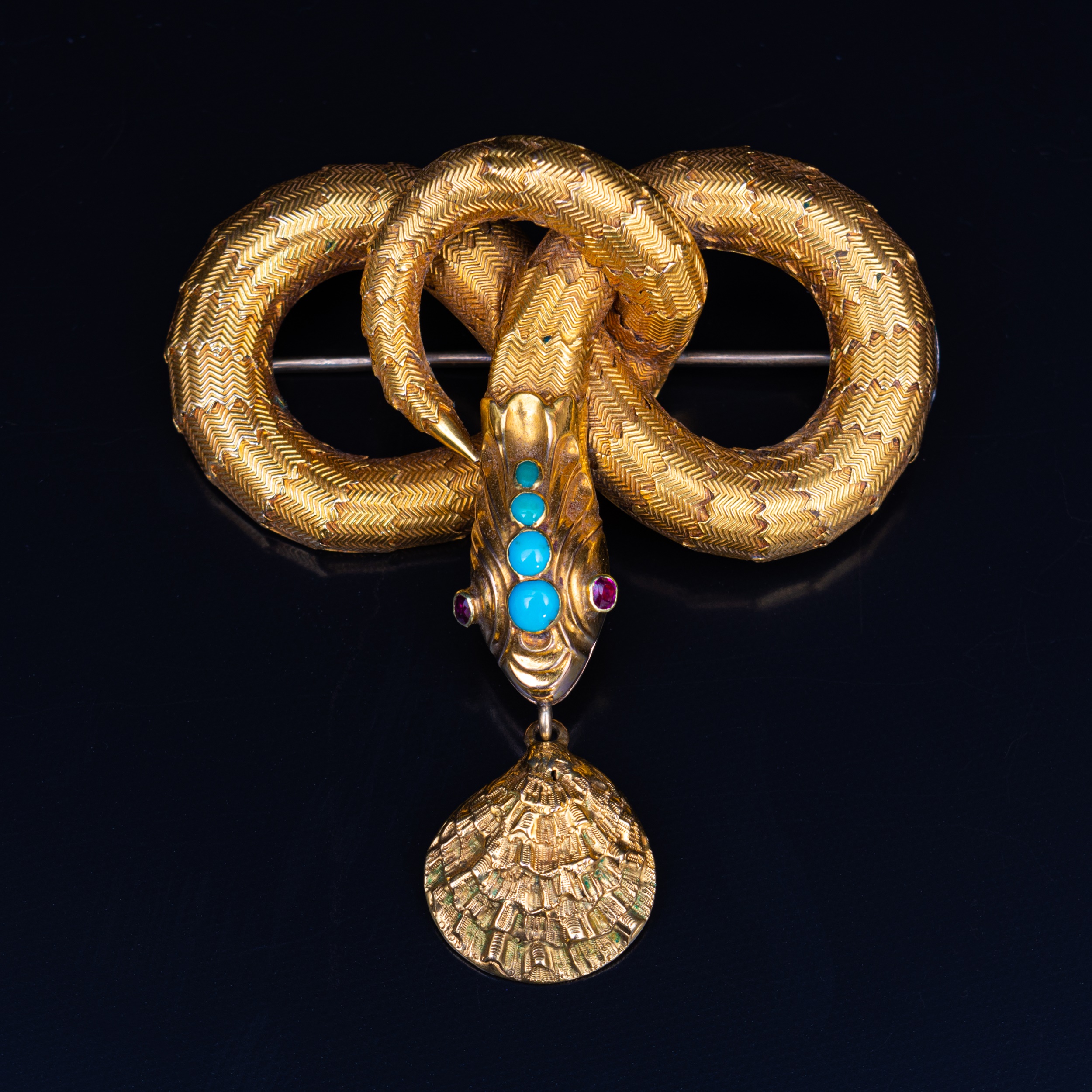 A mid 19th Century yellow metal brooch, in the form of a coiled snake with simulated scales,