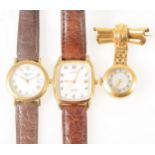 A yellow metal lapel watch and two gold-plated wrist watches.