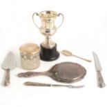 A silver trophy cup and other small silver wares.