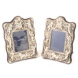 Two modern silver repousse chased photograph frames decorated with cherubs.