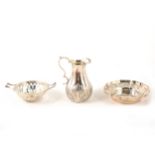 A silver jug with acanthus leaf border, fluted bonbon dish and another small pierced dish.