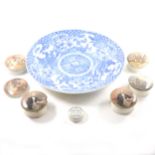 A large Chinese blue and white charger, seven Staffordshire pot lids, and decorative plates.