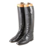 A pair of black leather hunting boots, sized 10, with wooden trees.