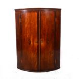 A George III oak and mahogany cylinder front hanging corner cupboard