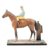 A cold-painted spelter match striker in the form of a racehorse with jockey