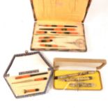 Two Art Deco Bakelite part writing sets and another "Foreign" three piece set.