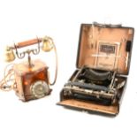 A vintage mahogany inlaid telephone and a cased Corona folding typewriter.