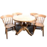 A circular pine kitchen table and four chairs