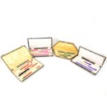 Four brightly coloured Art Deco writing sets.