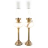 Pair of brass oil lamps with clear glass reservoirs