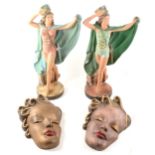 A pair of plaster Tiller Girl figurines and five plaster "mask" wall plaques.