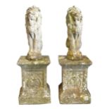 A pair of concrete models of lions passant, on square plinths