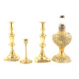 Brass candlesticks, a brass oil lamp converted to electricity, and four modern lamps.