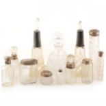 A small collection of silver-topped scent bottles and other dressing table jars.