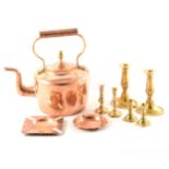 A copper kettle and various cast brass candlesticks and ashtrays