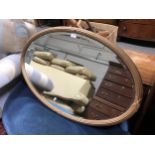 An oval gilt painted hall mirror, bevelled plate, reeded frame, 100cm x 65cm; another oval wall