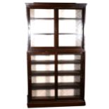 A stained beechwood two-heights bookcase, sliding glass doors, enclosing adjustable shelves,