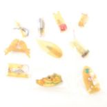 Ten Art Deco lucite dress clips and brooches, mostly in the "apple juice" and "lemon" colours.