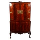 A reproduction mahogany finish cocktail cabinet, ornamental brass fitments, two panelled doors to