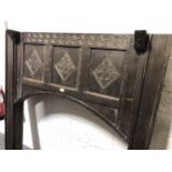 An oak fire surround, in part 18th Century, incorporating an oak coffer front, with a carved