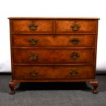 A walnut chest of drawers, fitted with two short and three long drawers, short cabriole legs,