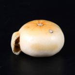 A Japanese carved and stained ivory model of a part-peeled satsuma, early 20th Century