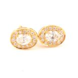 A pair of oval diamond cluster earrings.