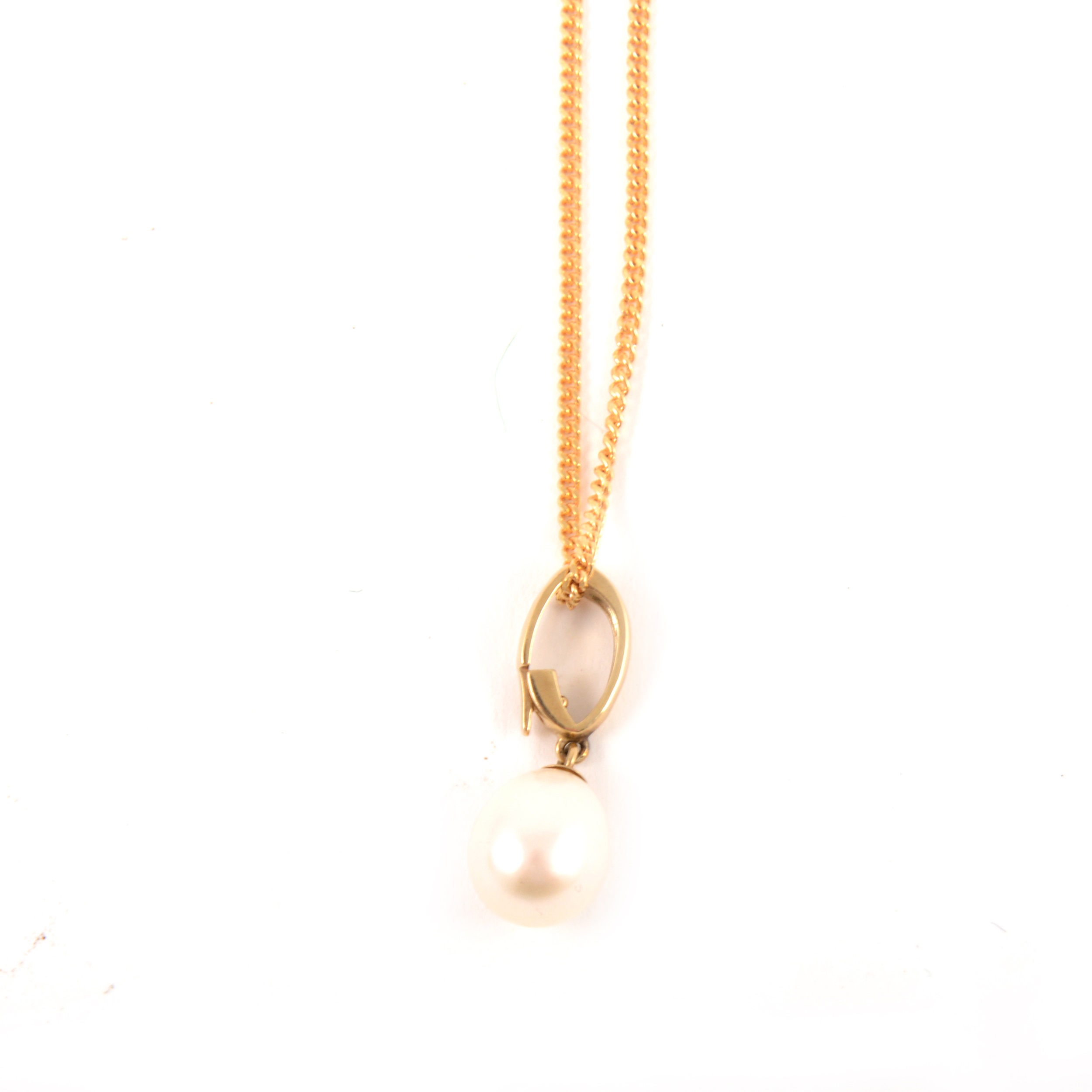 A pearl drop pendant and chain.