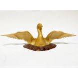 A carved satinwood sculpture of a bird with outstretched wings, contemporary craft