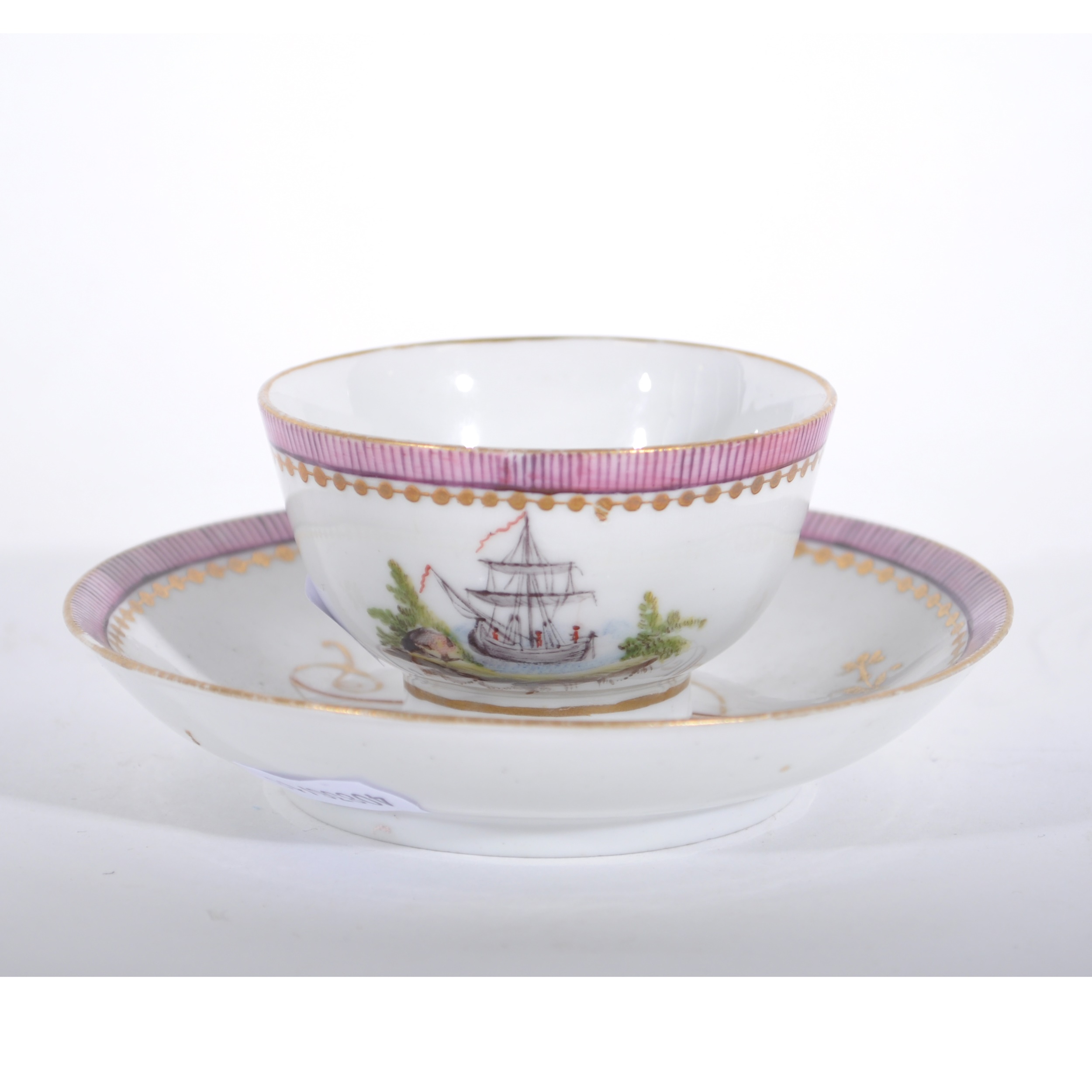 A tea bowl and saucer, painted ship and monogram, pink border, red anchor mark to base of both.