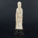 A Japanese carved ivory okimono, modelled as an elder