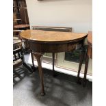 A reproduction figured walnut demi-lune tea table,