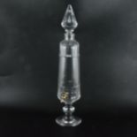 A glass liqueur urn, slender form, pointed stopper, metal tap, 51cm.