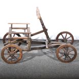 A vintage childs self-propelled four wheel oak cart.