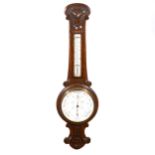 An Edwardian carved oak aneroid wall barometer,