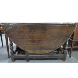 An old oak gateleg table, oval top, two leaves, frieze drawer, bobbin-turne