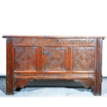 An oak three panel coffer, single plank top above a carved frieze and three
