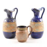 A pair of blue ground Doulton & Slaters stoneware ewers, 18cm, and another