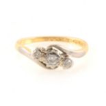 A diamond three stone crossover ring, the brilliant cut stones illusion set